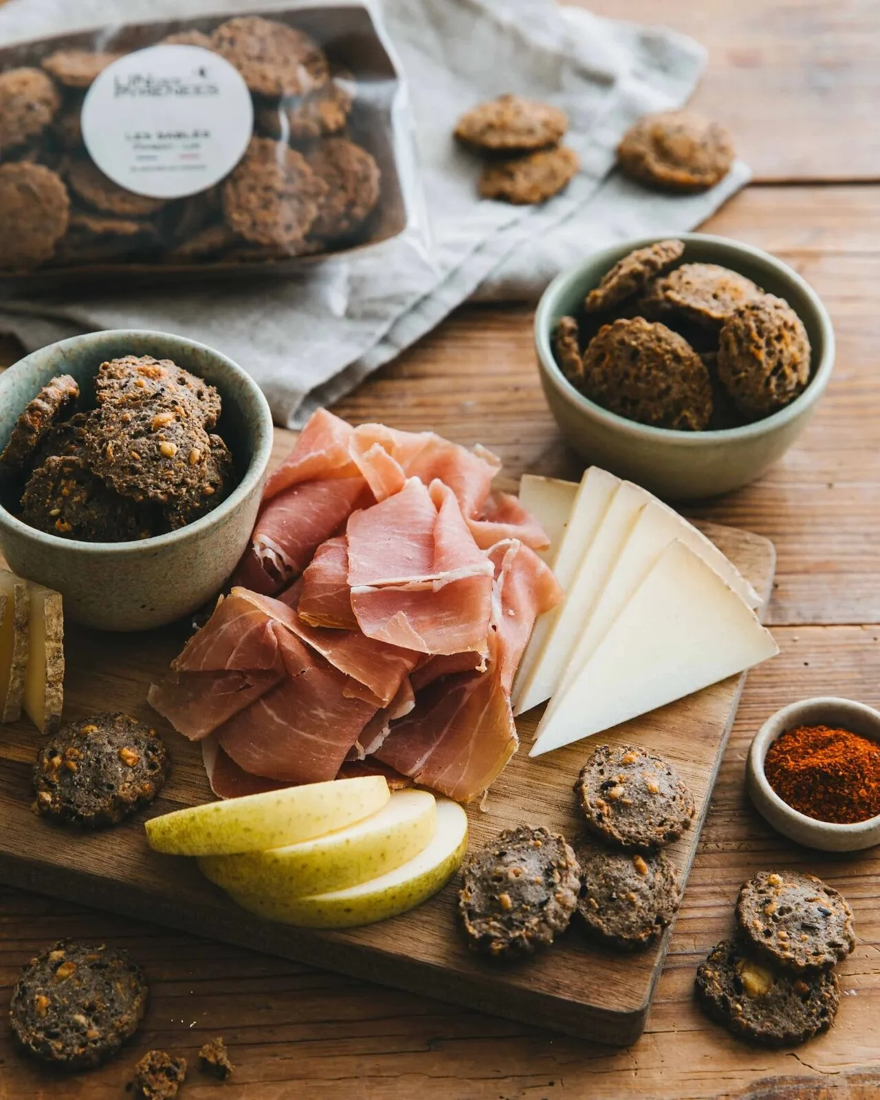 Aperitif board of flax shortbreads, dry-cured ham, ewe's cheese, pear and chilli