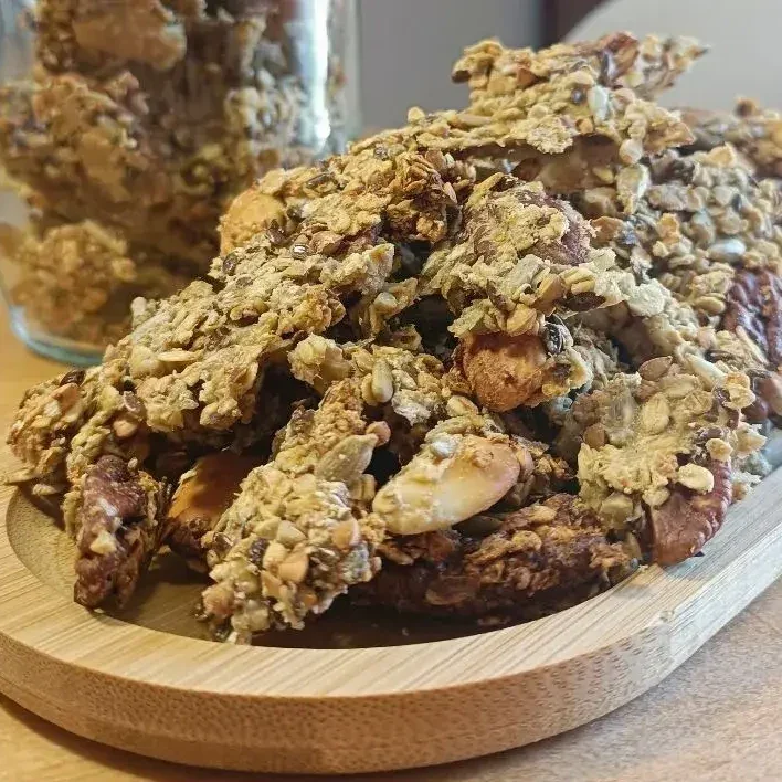 Granola sans sucre ajouté à la compote de pomme, sur un plateau en bois